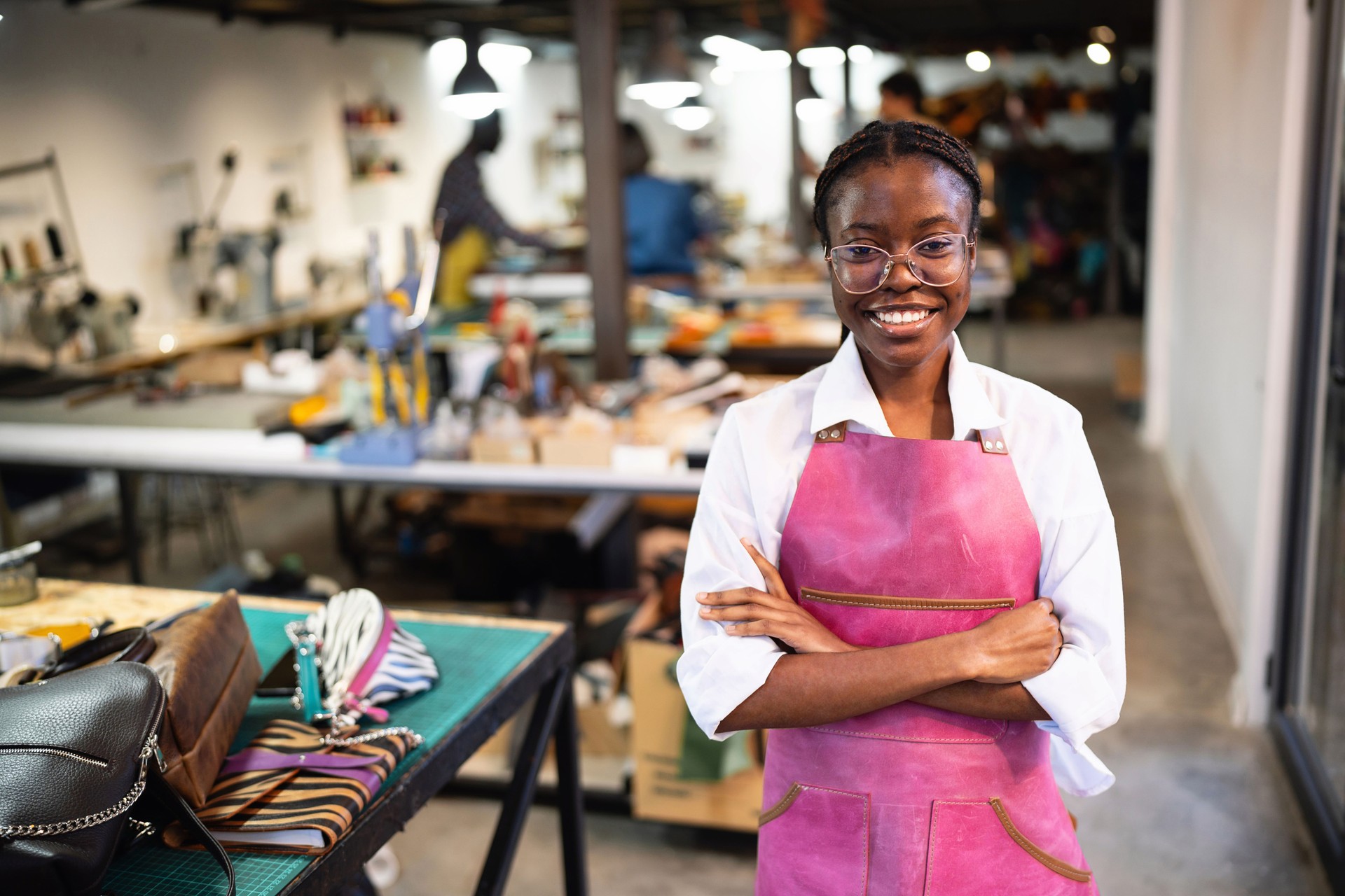 Young female tailor Black ethnicity, working at the leather factory